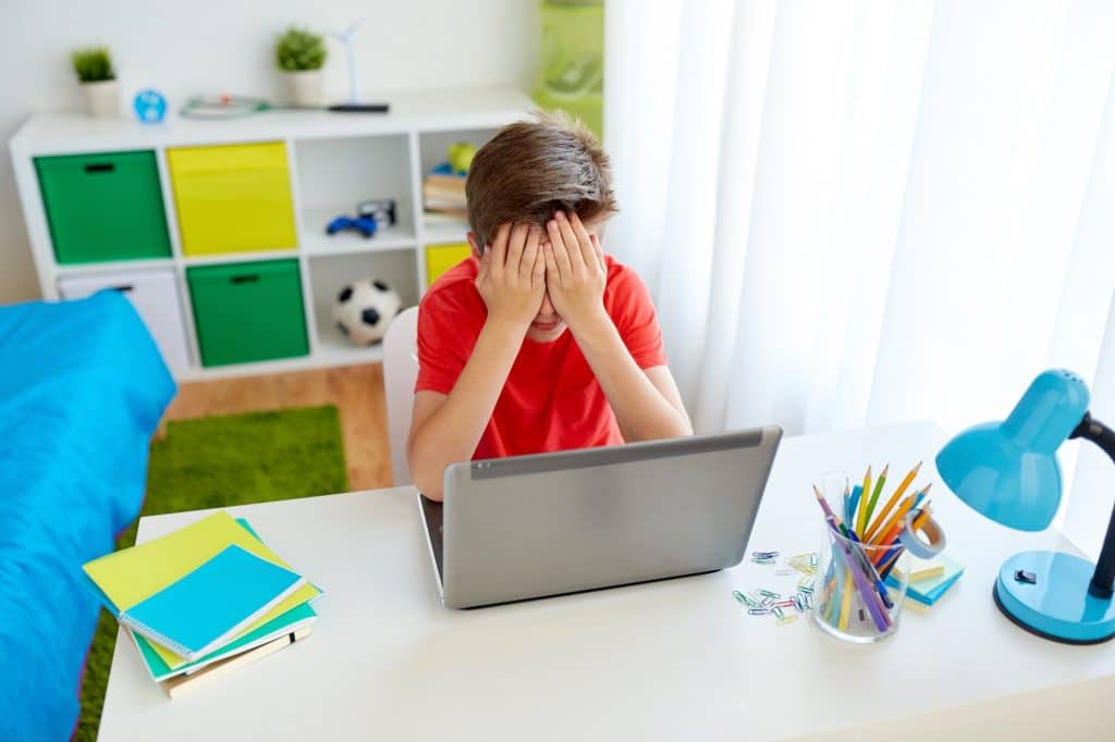 upset student boy with laptop computer at home